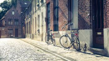 Bicycles at old building facade on cozy street, old provincial European town. Summer tourism and travels, famous europe landmark, popular places