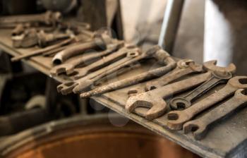 Old rusty wrenches and tools on the shelf, nobody. Metal rust, dirty spanners, corrosion, grungy equipment