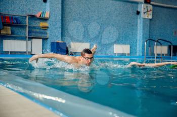 Male and female swimmers swims in the pool. Man and woman in the water, sport swimming skill training, motion view, workout before competition