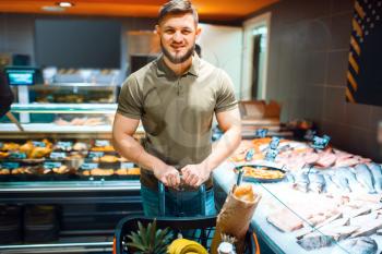 Man choosing fresh chilled fish in grocery store. Male person buying frozen food in market, customer shopping products in supermarket