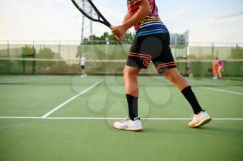 Athletic tennis players with rackets, training on outdoor court. Active healthy lifestyle, people play sport game, fitness workout with racquets