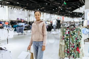 Cute woman standing like mannequin, clothing store. Female person shopping in fashion boutique, shopaholic, shopper looking on garment