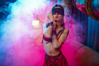 Sexy woman poses in bdsm suit and leather cat mask, abandoned factory interior on background. Young girl in erotic underwear, sex fetish