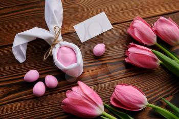 Pink tulips and easter egg on wooden background. Spring flowers blooming and paschal food, fresh floral decoration for holiday celebration