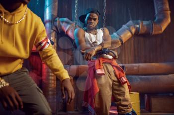 Two rappers poses, break-dance performing in studio with cool underground decoration. Hip-hop performers, trendy rap singers, break-dancers