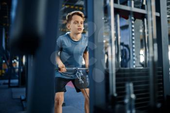 Boy on exercise machine, active training in gym. Youngster in sport club, healthcare and healthy lifestyle, schoolboy on workout, sportive youth