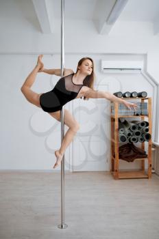 Sexy woman on pole-dancing workout in class. Girls with perfect body shows excellent stretching. Professional female dancers exercising in gym, pole dance