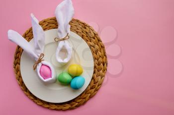 Easter eggs on decorative plate, pink background, top view. Paschal food, event decoration, spring holiday celebration symbol