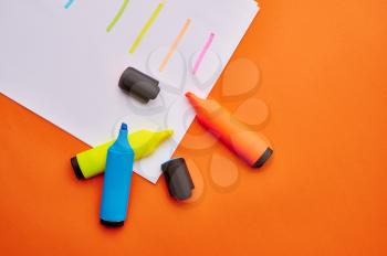 Set of opened colorful permanent markers on paper sheet with strokes. Office stationery supplies, school or education accessories, writing and drawing tools