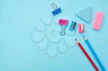 Pencils, clips and rubber on blue background. Office stationery supplies, school or education accessories, writing and drawing tools