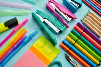 Office stationery supplies, blue background. School or education accessories, writing and drawing tools, pencils and rubbers, brushes and pens