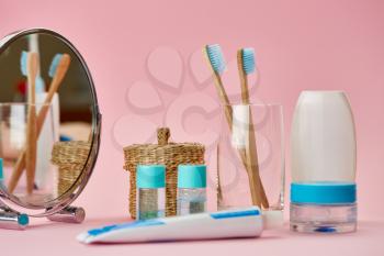 Oral care products, two toothbrush and toothpaste, macro view, pink background, nobody. Morning healthcare procedures concept, toothcare