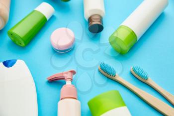 Oral and skin care products, blue background, nobody. Morning healthcare procedures concept, toothcare, toothbrush and toothpaste, brush and cream in bottle