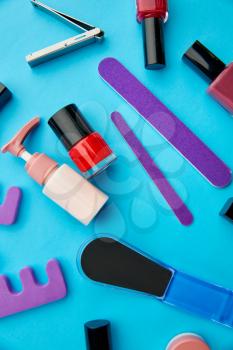 Nail care products, color polish in bottles on blue background, nobody. Healthcare procedures concept, fashion cosmetic, manicure and pedicure tools