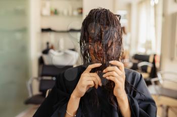 Female customer poses in hairdressing salon.Woman with wet hair in hairsalon. Beauty and fashion business, professional service