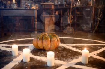 Magic circle with pumpkin and burning candles, closeup, demons casting out. Exorcism concept, mystery paranormal ritual, dark religion, night horror
