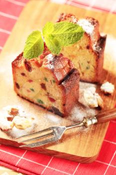 Two pieces of fruit cake on cutting board