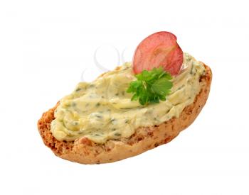 Crisp roll with herb butter isolated on white