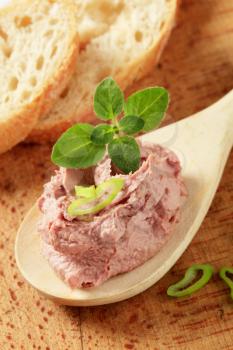 Liver pate on a wooden spoon and slices of bread