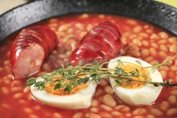 Baked beans with sausage and egg in a pan