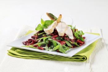 Slices of chicken breast with red beans and arugula