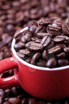 Roasted coffee beans in a red cup