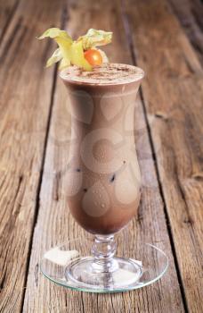 Glass of chocolate smoothie garnished with fresh fruit