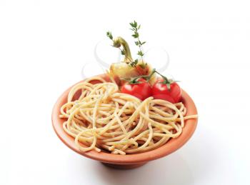 Cooked whole wheat spaghetti in a terracotta bowl