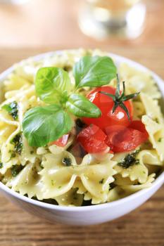 Bowl of bowtie pasta with pesto and tomatoes 