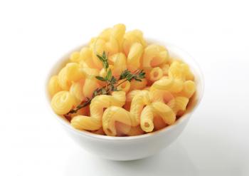 Bowl of cooked macaroni and sprig of thyme