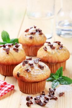 Fresh muffins sprinkled with sugar and chocolate shavings 