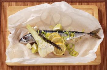 Fresh mackerel and other ingredients on cutting board