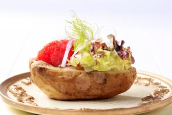 Baked potato and red caviar garnished with lettuce