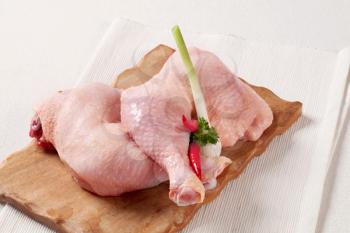 Raw chicken legs on a cutting board
