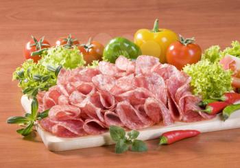 Slices of dry salami and fresh vegetables
