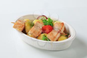 Fish skewer and potatoes in casserole dish