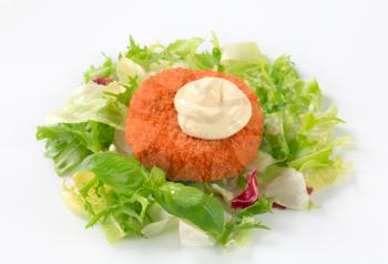 Fried breaded cheese with green salad and mayonnaise