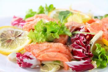 Green salad with pieces of smoked trout