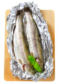 Two fresh trout on tin foil - cutout