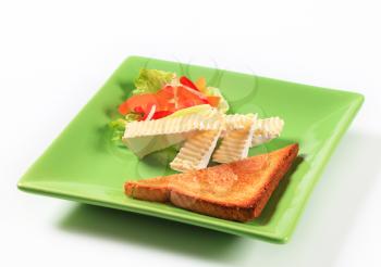 Toasted bread and wedges of white rind cheese