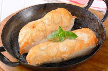Seared chicken breast fillets on a skillet