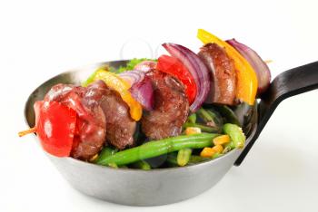 Liver skewer with green beans in a pan