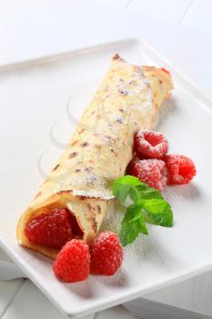 Crepe with fresh raspberries powdered with icing sugar