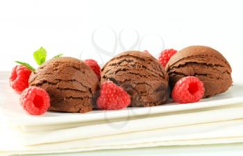 Scoops of chocolate ice cream with fresh raspberries