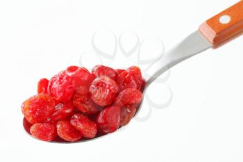 Dried red cherries on spoon