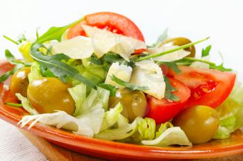 Fresh vegetable salad with green olives and Parmesan
