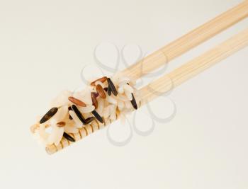 Rice on two wooden chopsticks - detail