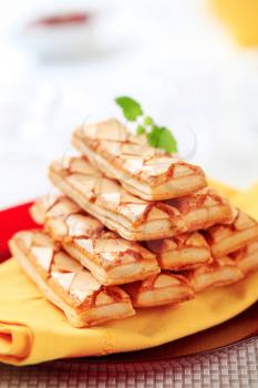 Stack of apricot glazed puff pastries on a plate