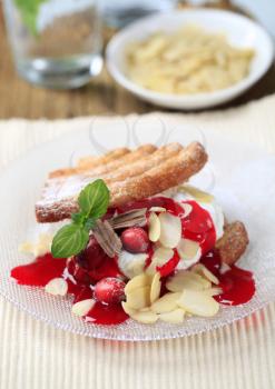 Fan-shaped puff pastries with cream, cranberries and syrup