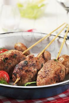 Minced meat kebabs and mushrooms in a pan